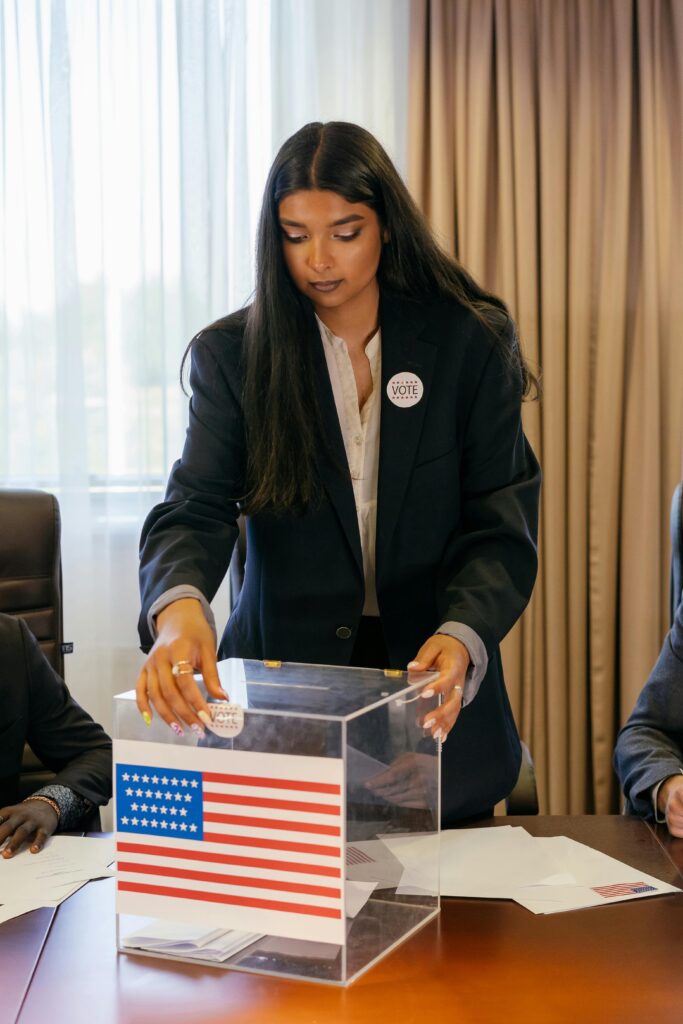 A young woman in a suit casts her vote during an election at a polling station.